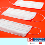 Image is three disposable white face masks on a plain red background 