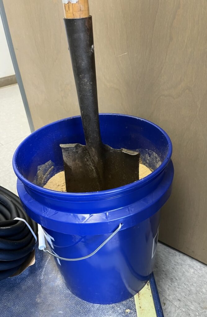 bucket of sand with spade standing up